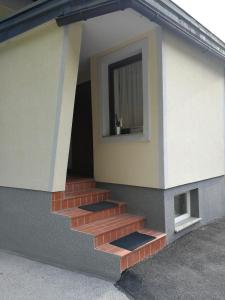 un edificio con una escalera con una ventana en él en Apartma Lip, en Rateče