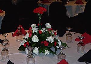 einen Tisch mit einer Vase aus roten und weißen Blumen in der Unterkunft Isle of Capri Casino Hotel Lula in Lula