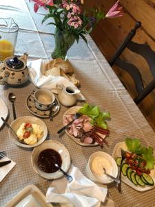 a table with plates of food and a vase of flowers at Skrawek Nieba in Ropa