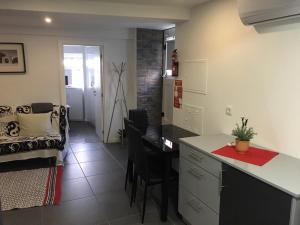 a kitchen with a desk and a table in a room at Escadinhas da Sé in Viseu