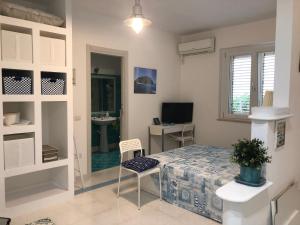 a bedroom with a bed and a desk and a television at LA MESONETTE A DUE PASSI DAL MARE in Tropea