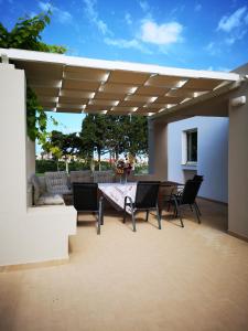 a patio with a table and chairs under a pergola at Villa Leonidas in Mastihari
