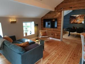 a living room with a blue couch and a television at Østigård 1810 Gamlehuset in Åndalsnes