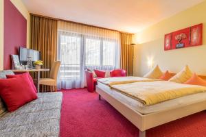 una camera d'albergo con un letto grande e una scrivania di Hotel Alex a Leukerbad