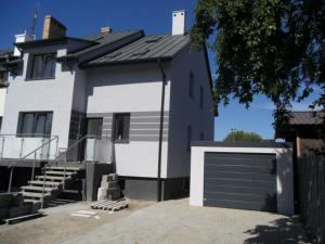 a white house with a garage door and stairs at Willa Magnolia in Szczecin