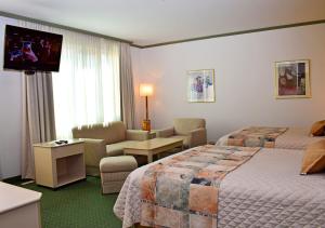 a hotel room with two beds and a flat screen tv at Hotel Europa in La Paz