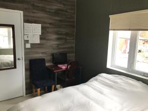 Schlafzimmer mit einem Bett, einem Schreibtisch und einem Fenster in der Unterkunft Auberge Internationale Espace Globetrotter in Rimouski