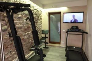a room with a gym with a treadmill and a tv at Casa Vacanze Agnese in San Felice del Benaco