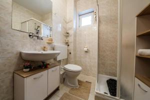 ein Badezimmer mit einem WC, einem Waschbecken und einem Spiegel in der Unterkunft Maria Guest House in Kaštela
