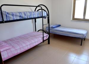 a room with two bunk beds and a window at Holiday Home Marina in Marina di Gioiosa Ionica