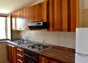 a kitchen with wooden cabinets and a stove top oven at Holiday Home Marina in Marina di Gioiosa Ionica
