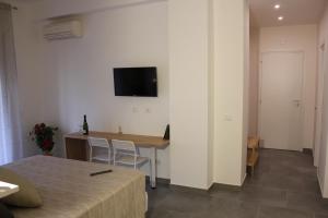 Una habitación con una mesa y un televisor en la pared. en LA FINESTRA SUL PORTO, en Palermo