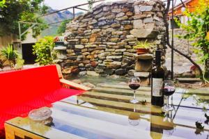two glasses of wine sitting on a table in front of a fountain at Oasis Mtskheta in Mtskheta