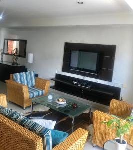 a living room with a tv and chairs and a table at Apartamento Amoblado En Bucaramanga in Bucaramanga