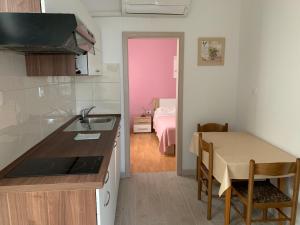 eine Küche mit einem Waschbecken und einem Tisch in einem Zimmer in der Unterkunft Apartments Ostanek in Portorož