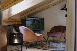 a living room with two chairs and a television at Monastery Garden Bistro & Rooms in Český Krumlov