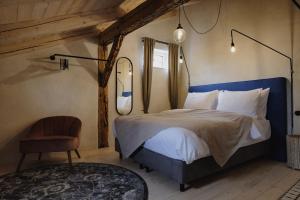 a bedroom with a bed and a chair and a mirror at Monastery Garden Bistro & Rooms in Český Krumlov
