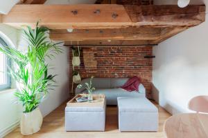 a living room with a couch and a brick wall at Apartamenty Monka in Toruń