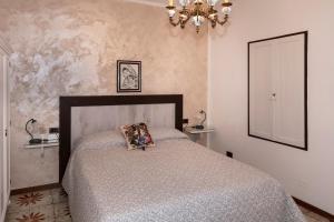 sypialnia z łóżkiem i żyrandolem w obiekcie Casa Vacanze Agnese w mieście San Felice del Benaco