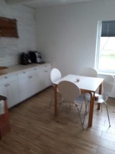 a kitchen with a table and chairs in a room at Kaimo Vila “Padange” in Kančėnai