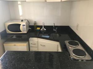 a small kitchen with a sink and a microwave at Crystal Place 2 in Goiânia