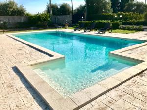 una piscina de agua azul en un patio en Villa Stefy apartments, en Avola