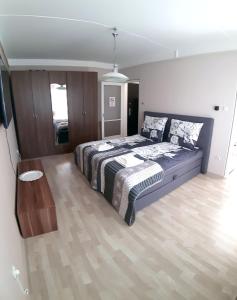 een slaapkamer met een groot bed en een houten vloer bij Katica Apartman in Miskolc