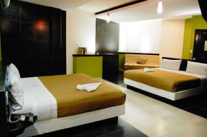 a hotel room with two beds and a couch at Hotel Porto Novo in Veracruz