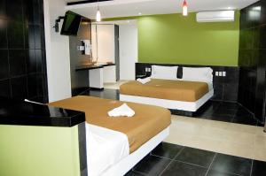 a hotel room with two beds and a green wall at Hotel Porto Novo in Veracruz