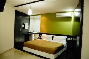 a bedroom with a bed with a green wall at Hotel Porto Novo in Veracruz