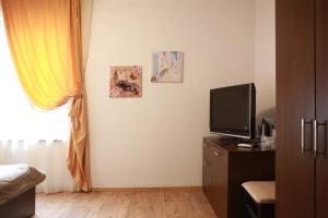 a bedroom with a tv and a window and a dresser at Hotel Slivnitsa in Burgas