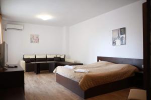 a bedroom with a bed and a couch in it at Hotel Slivnitsa in Burgas