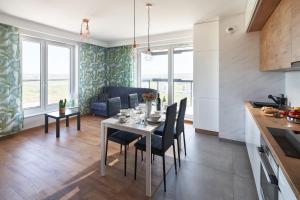a kitchen and living room with a table and chairs at Apartament Premium Aquatower Reda in Reda