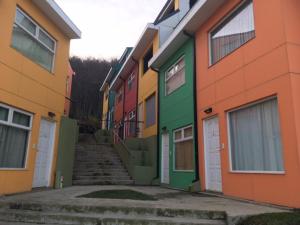 una fila di case colorate con scale tra di loro di La Comarca Aparts IV a Ushuaia