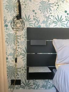 a bedroom with a bed and a wall with floral wallpaper at ROOM 10 in Valmiera