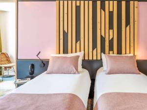 ブローニュ・シュル・メールにあるibis Styles Boulogne sur Mer Centre Cathédraleのベッド2台が隣同士に設置された部屋です。