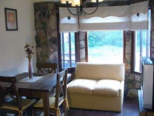 a living room with a table and a couch and a table and window at Complejo Ayenué & Spa in Ostende