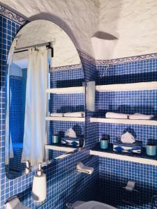 a blue tiled bathroom with a sink and a mirror at Son Vent in Caʼs Concos