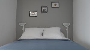a bedroom with a bed with three pictures on the wall at Appartement Le Mans Libération in Le Mans