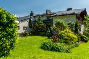 a house with a yard with green grass and bushes at Między Zdrojami in Rymanów