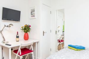 a bedroom with a desk and a bed with a tv at Bristol City Budget Studio Stay in Bristol