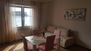 a living room with a table and chairs and a couch at Banjol 441 Apartman mare in Rab