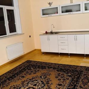 a kitchen with a sink and white cabinets and a rug at ElVin in Quba