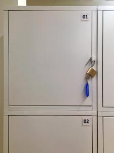 a white cabinet with a door with numbers on it at Bakkegata - Blue House Dormitory in Odda