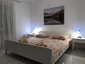 a bedroom with a bed with two lamps on two tables at Apartments Stefan in Sveti Stefan