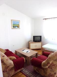 een woonkamer met 2 stoelen en een tafel en een bed bij Nada Apartments in Poreč