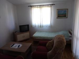 een kleine woonkamer met een bank en een bed bij Nada Apartments in Poreč