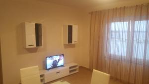 a living room with a tv and a window at Banjol 441 Apartman mare in Rab