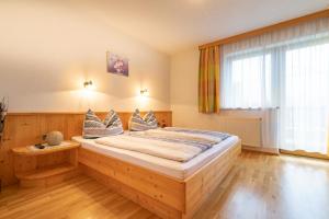 a bedroom with a wooden bed with pillows on it at Landhaus Sonnblick in Zellberg