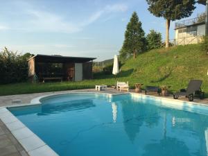 a swimming pool in a yard with a table and chairs at Al Sasso in Città di Castello